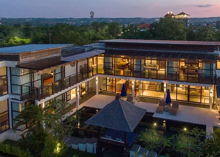 Multi-storey boutique hotel building at dusk with balcony terraces