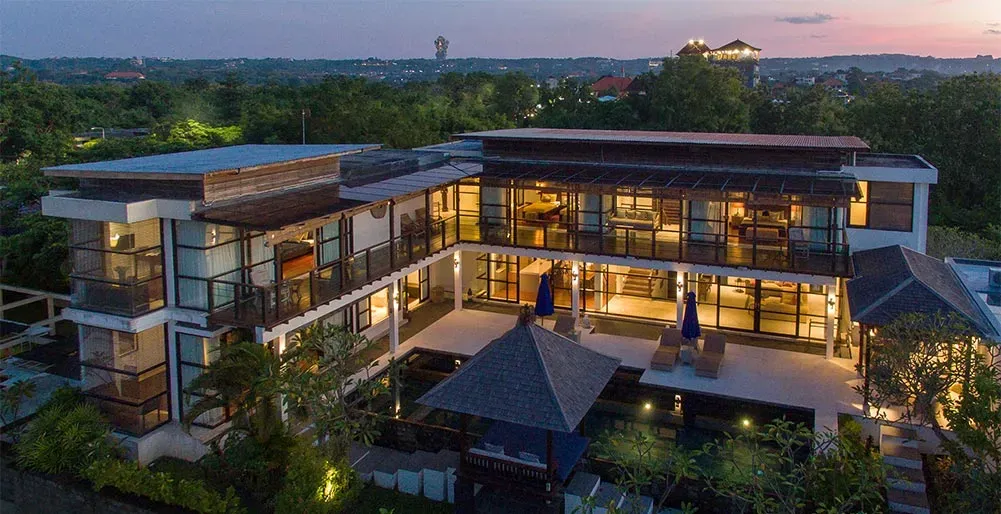 Multi-storey boutique hotel building at dusk with balcony terraces