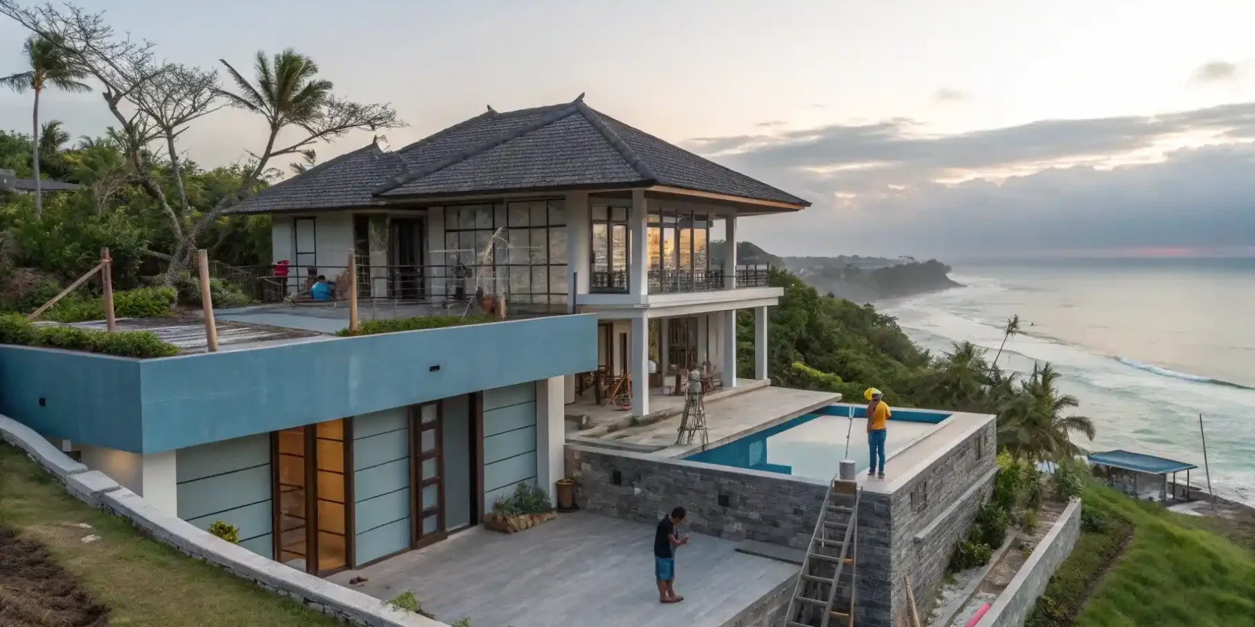 A clifftop villa under construction with its pool deck finished above a surf break