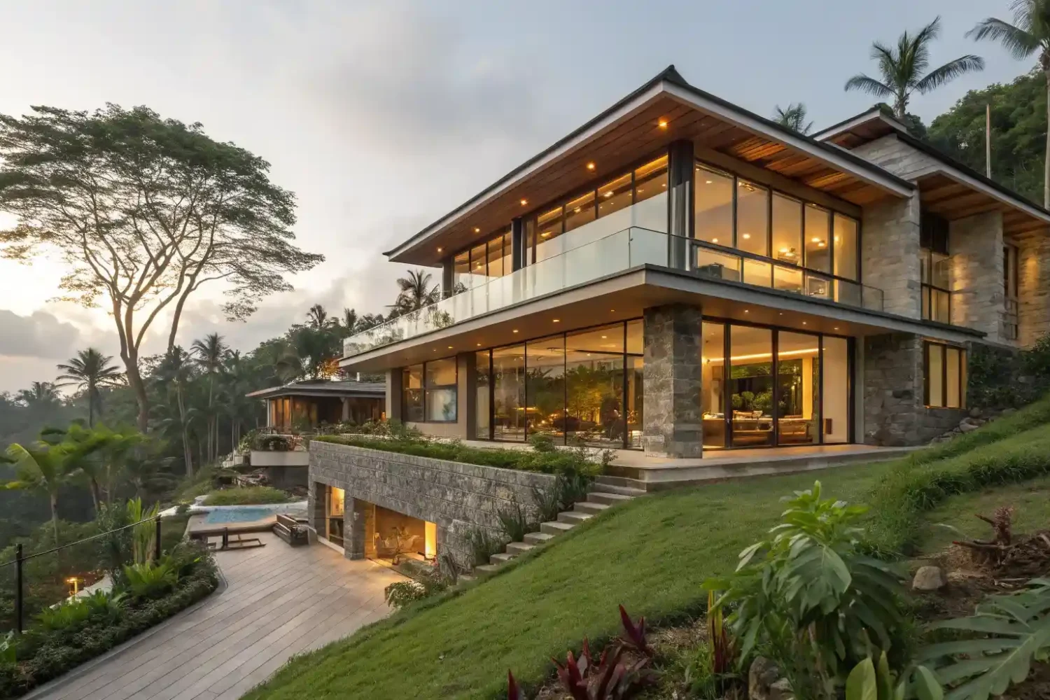 A completed contemporary Balinese villa lit at dusk on a planted hillside