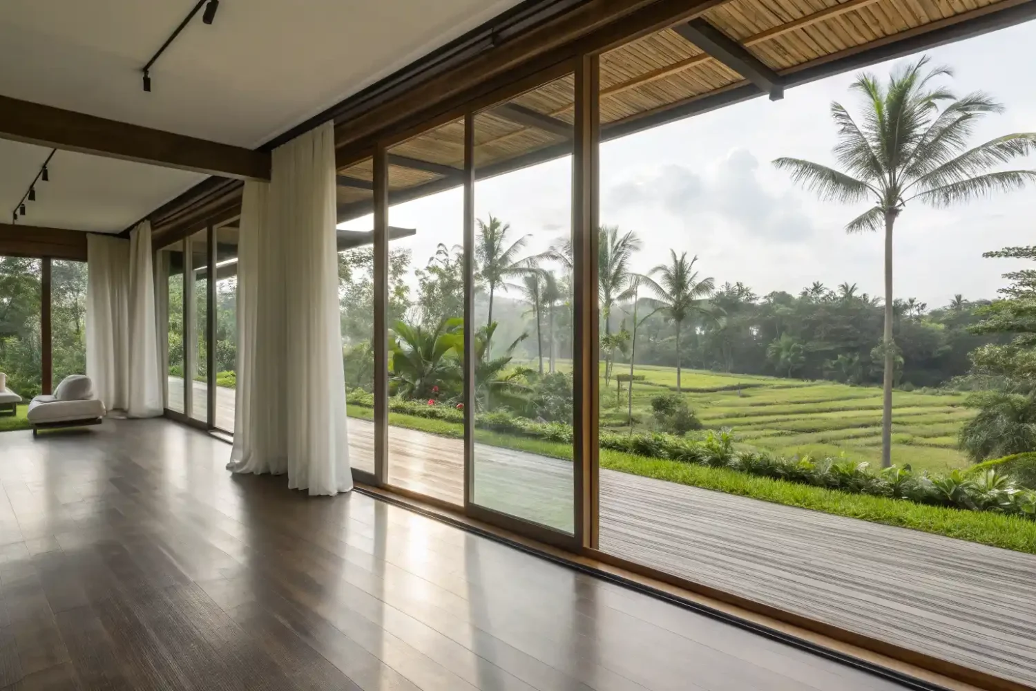 An empty villa pavilion opening onto terraced rice fields and palms in Bali
