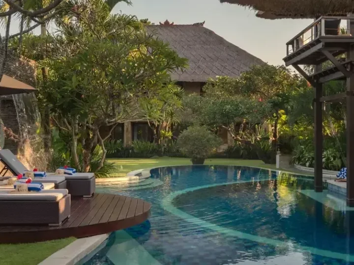Villa pavilion with alang-alang roof beside a garden lap pool